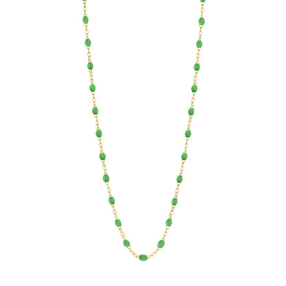 The Gigi Clozeau Classic Gigi Necklace, 16.5", is a stunning accessory that showcases a yellow gold chain adorned with striking jewels and evenly spaced green oval beads.