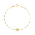 The In Love Diamond Bracelet 6.7" by Gigi Clozeau features a gold chain with small black resin pearls and a central heart pendant adorned with clear stones, crafted in 18k yellow gold, shown on a white background.