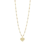 The Gigi Clozeau In Love Diamond Necklace 16.5" features yellow gold with small white opal resin pearls and a heart pendant studded with clear stones, elegantly displayed on a plain white background.