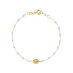 The Gigi Clozeau Madone Charm Bracelet 6.7" features alternating small blue resin pearls, a central 18k gold medallion, and a lobster clasp closure.