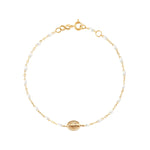 The Madone Charm Bracelet 6.7" by Gigi Clozeau features elegant resin pearls, a round medallion charm, and is crafted from 18k gold with a secure lobster clasp.