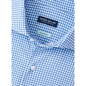 Close-up of a blue and white gingham Peter Millar Excursionist Flex Sport Shirt featuring an "ExactaLuxe Flex" tag near the collar.