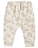 Quincy Mae’s Baby and Kids’ Drawstring Pant in cream is crafted from soft organic brushed jersey, featuring an elastic waistband and adorned with a delicate pattern of small, muted pastel flowers and leaves.