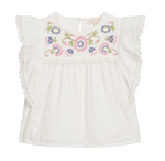 The Girls’ Maiya Blouse by Louise Misha is a white short-sleeve cotton gauze blouse featuring ruffled lace trim and multicolored floral embroidery on the chest.