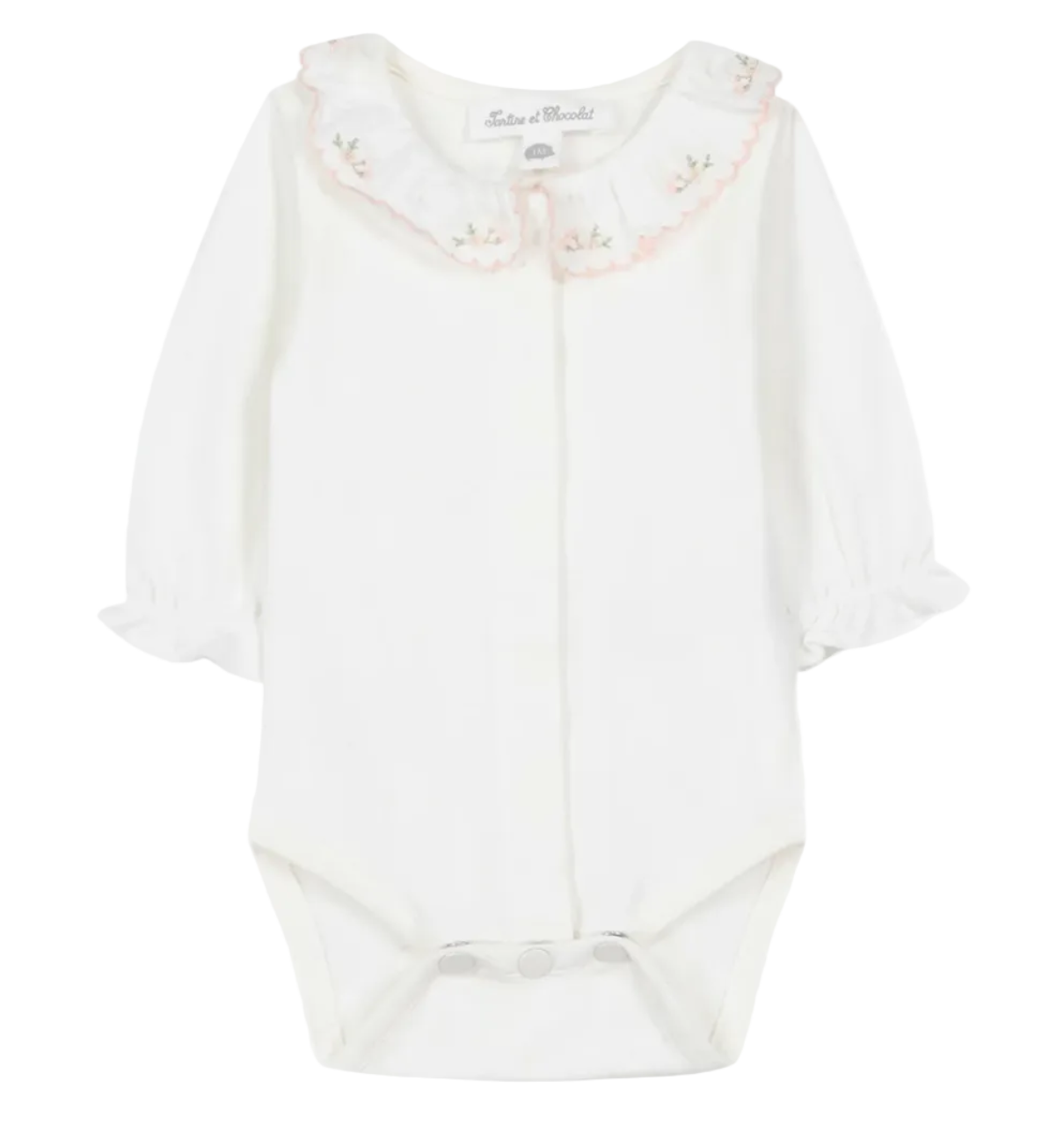 The Tartine et Chocolat Baby Girls’ Ruffled Collar Bodysuit is a white long-sleeve onesie crafted from soft ecru cotton, featuring ruffled cuffs, convenient snap closures, and an embroidered scalloped collar adorned with delicate floral details. This charming bodysuit blends comfort and elegance for a sweet, timeless look.