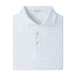 The Peter Millar On The Line Performance Jersey Polo is a neatly folded white polo shirt featuring a subtle blue floral pattern and three light-colored buttons, crafted with four-way stretch for all-day comfort.