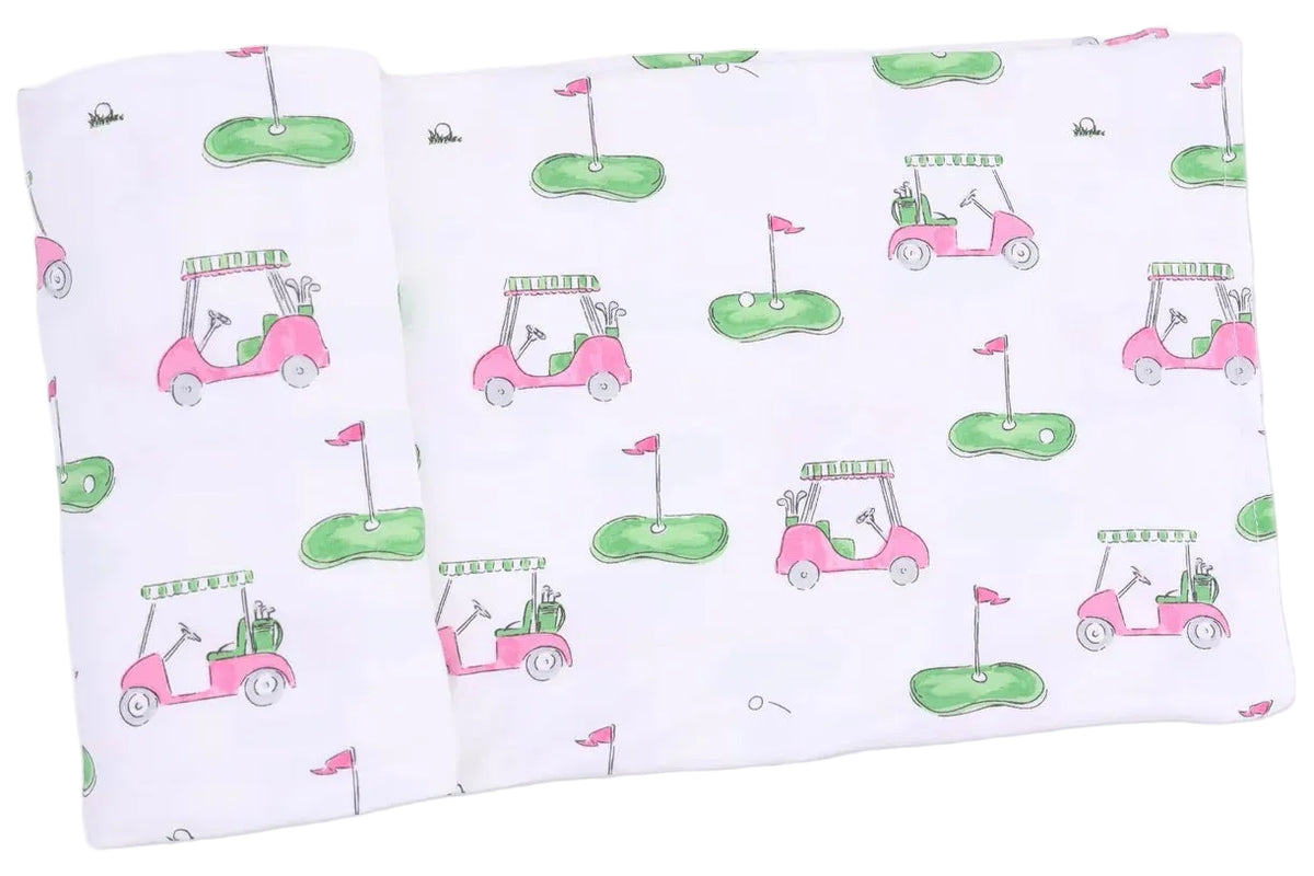 A soft and breathable white Swaddle Blanket by Angel Dear, this adorable baby swaddle features a repeating pattern of pink and green golf carts, putting greens with flags, and small golf balls—perfect for your little one.