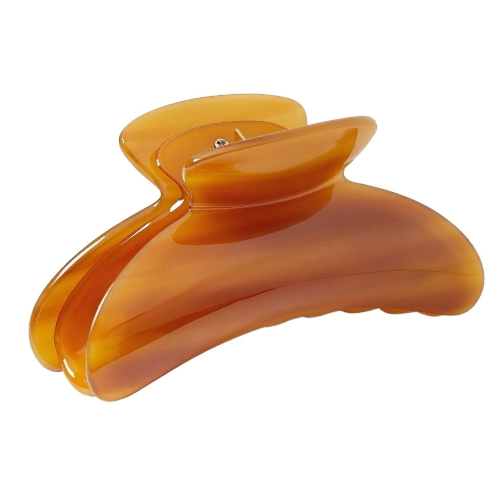 A large amber-colored Machete Grande Heirloom Claw hair claw clip isolated on a white background.