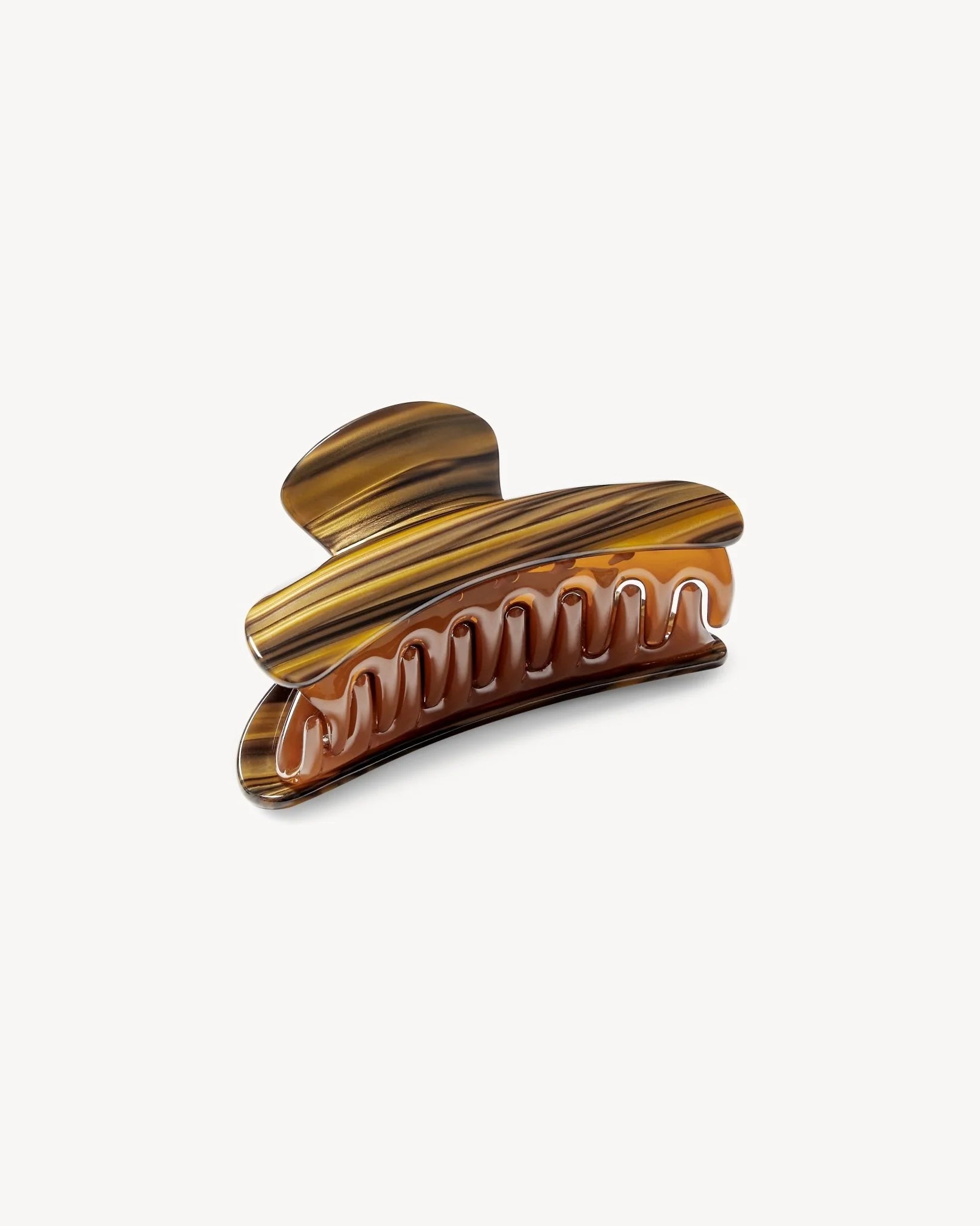 Introducing the Grande Heirloom Claw by Machete—a brown and amber marbled hair claw clip, expertly crafted from luxurious Italian acetate. Featuring a curved design with interlocking teeth, it’s ideal for securing long, thick, or voluminous hair. Shown against a plain white background.