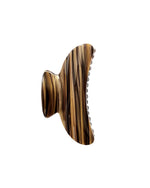 The Grande Heirloom Claw by Machete is a brown and black striped hair clip with a curved design and teeth, expertly crafted from Italian acetate—perfect for securing large volume or long, thick hair; shown isolated on a white background.