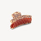 The Machete Grande Heirloom Claw is a large hair clip crafted from premium Italian acetate, featuring a chic checkerboard pattern in brown, beige, and cream hues. Designed with interlocking teeth and a gracefully curved shape, this stylish accessory is ideal for securing long, thick hair. Shown against a plain white background.