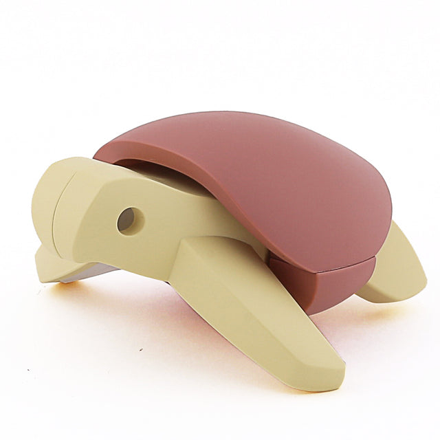 A small, stylized turtle figurine from the Halftoys Ocean Friends collection by Halftoys, featuring a beige body and dark pink shell, is positioned on a white background.