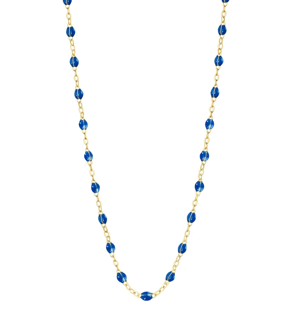 The Gigi Clozeau Classic Gigi Necklace 16.5" from Gigi Clozeau is crafted from 18 carat yellow gold and features striking jewels with small blue beads evenly spaced along the chain.