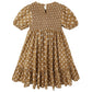 The Girls' Lydia Dress by Rylee & Cru is a brown, knee-length smocked dress with short sleeves, a white floral pattern, ruffled hem, and button closure at the back.
