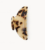 The Machete Midi Heirloom Claw, crafted from premium Italian acetate in a tortoiseshell pattern, features a curved, wing-like design and reinforced hardware, shown against a plain white background.