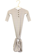The Lou Lou & Company Baby Boys’ Banks Knotted Gown, featuring long sleeves, stripes, a button-down front, and a knotted tie-bottom for easy diaper changes, is displayed on a gold hanger against a white background.