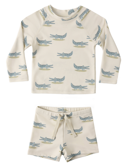 The Rylee & Cru Baby Boys' Rashguard Set includes a cream-colored long-sleeve top and shorts with a green and blue alligator print.