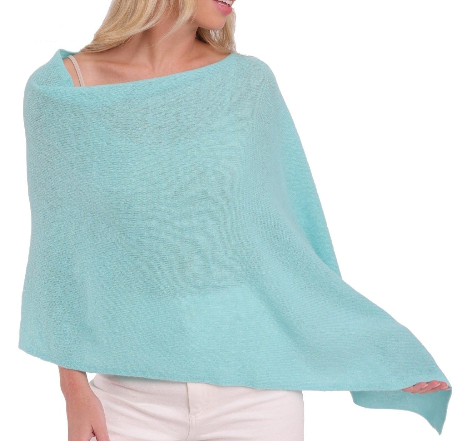 A woman in an Alashan Cashmere turquoise Cashmere Dress Topper Poncho, perfect for day-to-night wardrobe.