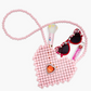 The Super Smalls Heartfelt Sparkle Pearl Handbag, child-sized heart sunglasses, a makeup brush, and pink lip gloss are arranged on a white background.