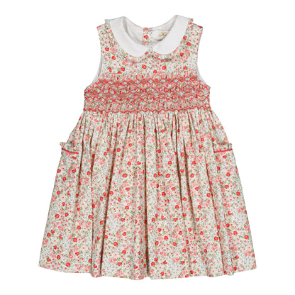 The Kidiwi Baby Girls' and Girls' Ixia Smocked Dress features a sleeveless cotton floral design in cherry red and green with a white Peter Pan collar, smocked bodice, and side pockets—ideal as a charming summer dress.