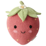 Introducing the Baby Strawberry by Cuddle + Kind—a handcrafted plush toy made from the finest Peruvian cotton, featuring a knitted strawberry design with a smiling face, rosy cheeks, green leaves on top, and a delicate white flower. This irresistibly soft baby toy is perfect as a charming heirloom piece to enhance any cherished collection.