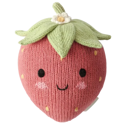 Introducing the Baby Strawberry by Cuddle + Kind—a handcrafted plush toy made from the finest Peruvian cotton, featuring a knitted strawberry design with a smiling face, rosy cheeks, green leaves on top, and a delicate white flower. This irresistibly soft baby toy is perfect as a charming heirloom piece to enhance any cherished collection.