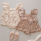 Two Noralee Baby Girls' Margot Rompers in cream and dusty pink, each with floral prints and large bows, are paired with pink baby shoes—a perfect special occasion outfit inspired by the charming Margot Romper.