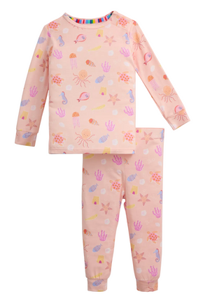 The Baby Girls’ and Girls’ Deep Chic Magnetic PJ Set by Magnetic Me features long sleeves in light pink with an ocean-themed pattern of pastel jellyfish, seashells, seahorses, and starfish. Made from soft modal fabric, this set offers a sustainable and comfortable night’s sleep.