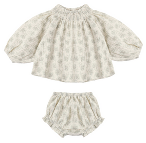 The Baby Girls’ Quincy Set from Rylee & Cru includes a long-sleeve blouse with elastic neck and cuffs, paired with a coordinating bloomer. Both pieces feature a light grey floral print on an off-white background for a timeless, delicate style.
