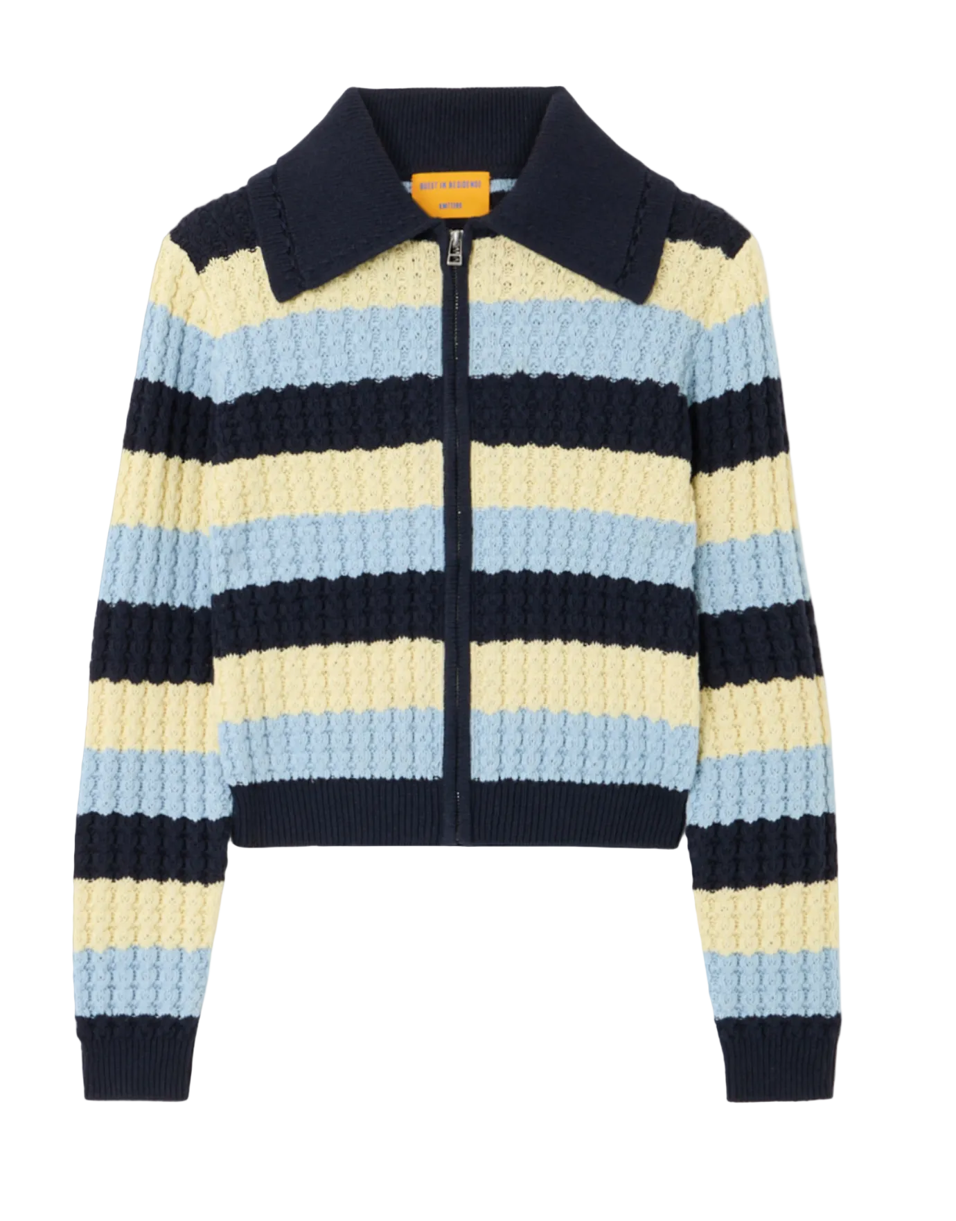 The Kirby Jacket by Guest in Residence is a cropped women's knit zip-up cardigan with long sleeves, wide navy blue, light blue, and pale yellow stripes, a pointed collar, and is crafted from a soft silk–organic cotton blend.