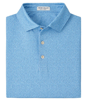 A folded light blue Peter Millar Magnolia Performance Jersey Polo with a subtle white floral pattern, two-button placket, and four-way stretch for all-day comfort.