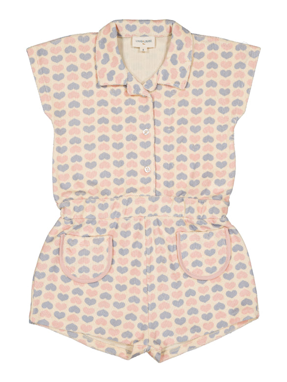 Girls’ Lola Terry Heart Overall by Louis Louise: a short-sleeve terrycloth romper featuring a collar, button front, and pockets, adorned with pastel pink, blue, and beige hearts on textured fabric.