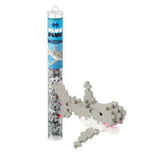 A Plus Plus Tube - Shark stands beside a finished gray and white shark model, encouraging creative play and helping to develop fine motor skills.