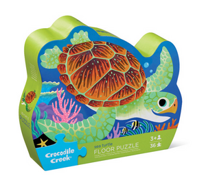 The Crocodile Creek Sea Turtle Puzzle is a 36-piece floor puzzle in a sea turtle-shaped box, featuring a vibrant illustration and made from recycled cardboard for ages 3 and up.