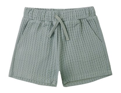 The Boys' Relaxed Short by Rylee & Cru features a light green color, soft fabric, elastic waistband with adjustable drawstring, and two side pockets, shown on a white background.