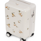 Konges Slojd Kids’ Travel Suitcase in off-white featuring a repeating dinosaur and palm tree pattern with a TSA lock on the side.