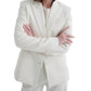 Woman in a white single-breasted TWP Husband Linen Jacket crossing her arms, standing against a plain white background.