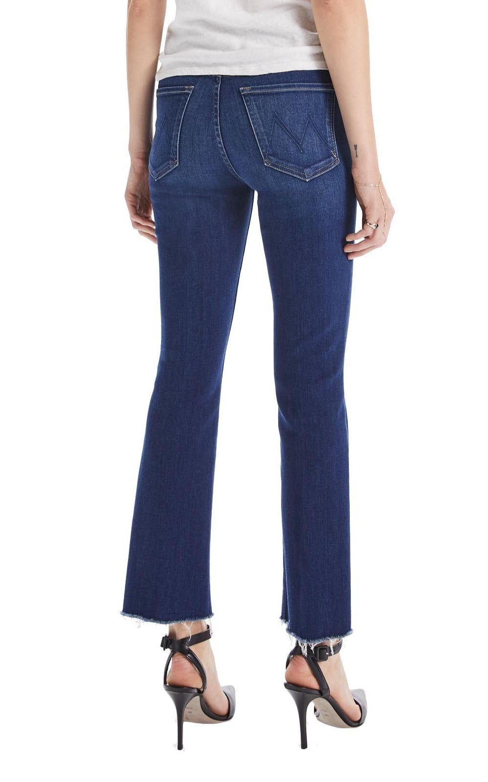 A woman in Mother Denim The Hustler Ankle Fray jeans with a raw hem, made of a cotton blend, seen from the back.