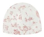 The Baby Fantasy Garden Cotton Beanie by Tartine et Chocolat is a white baby hat adorned with a delightful fantasy garden print in pink, featuring charming illustrations of toys, animals, and plants, and accented with a small fabric button on the front.