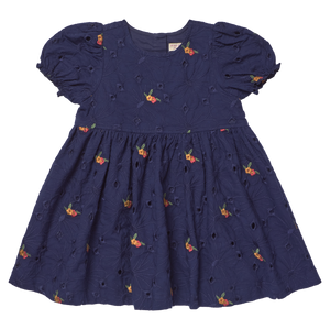 The Girls' Eliza Eyelet Embroidery Dress from Pink Chicken is a navy blue short-sleeve dress adorned with delicate eyelet embroidery and small orange floral patterns. Featuring puffed sleeves and a gathered skirt, this charming style offers cheerful elegance for any occasion, making it the perfect girls' fall dress inspired by classic silhouettes.