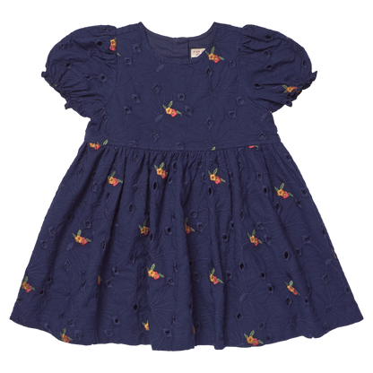 The Girls' Eliza Eyelet Embroidery Dress from Pink Chicken is a navy blue short-sleeve dress adorned with delicate eyelet embroidery and small orange floral patterns. Featuring puffed sleeves and a gathered skirt, this charming style offers cheerful elegance for any occasion, making it the perfect girls' fall dress inspired by classic silhouettes.