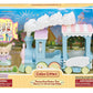 The Calico Critters Floating Cloud Rainbow Train playset features a pastel blue and white train, a critter figurine, and accessory pieces—perfect for creating your own magical Amusement Park adventure. Recommended for ages 3 and up.