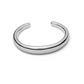 The Lie Studio Amanda Bracelet is a polished silver piece with a simple, rounded design and an open end, shown resting on a white background.