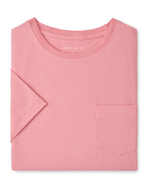 The Peter Millar Crown Comfort Pocket Tee is a pink, short-sleeve t-shirt with a chest pocket, made from soft organic cotton midweight fabric and shown folded on a plain white background.
