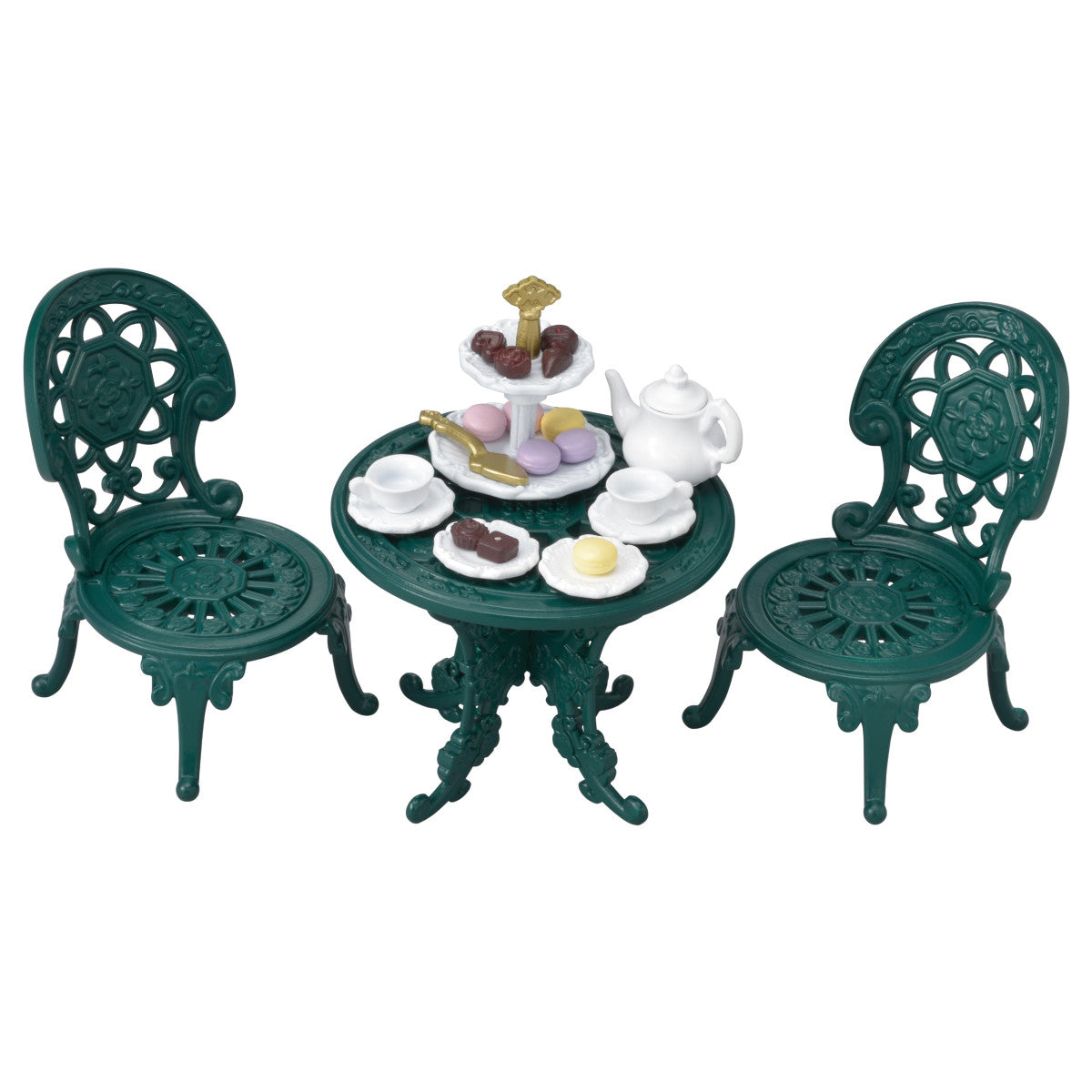 The Calico Critters Tea and Treats Set features two ornate green chairs and a matching garden table, charmingly arranged with tea party accessories like a white teapot, teacups, plates, and a tray of assorted pastries and sweets.