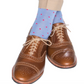 Brown leather brogue shoes with a durable design are paired with Dapper Classics Dot Mid Calf Socks in light blue featuring small pink dots and beige trousers.