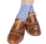 Brown leather brogue shoes with a durable design are paired with Dapper Classics Dot Mid Calf Socks in light blue featuring small pink dots and beige trousers.