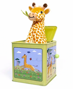 A plush giraffe pops out of the Jack-in-the-Box by Jack Rabbit Creations, a green toy adorned with original art featuring charming giraffe illustrations and a side winding knob.