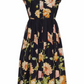 The Octavia Dress by Cara Cara is a sleeveless, collared, belted shirtdress with a button-down front and box pleat skirt, featuring a black base with bold peach, pink, and green floral print.