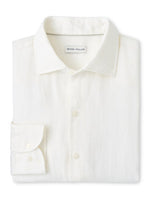 The Shoreside Linen Sport Shirt by Peter Millar is a white, folded sport shirt with a pointed collar, displaying refined craftsmanship.
